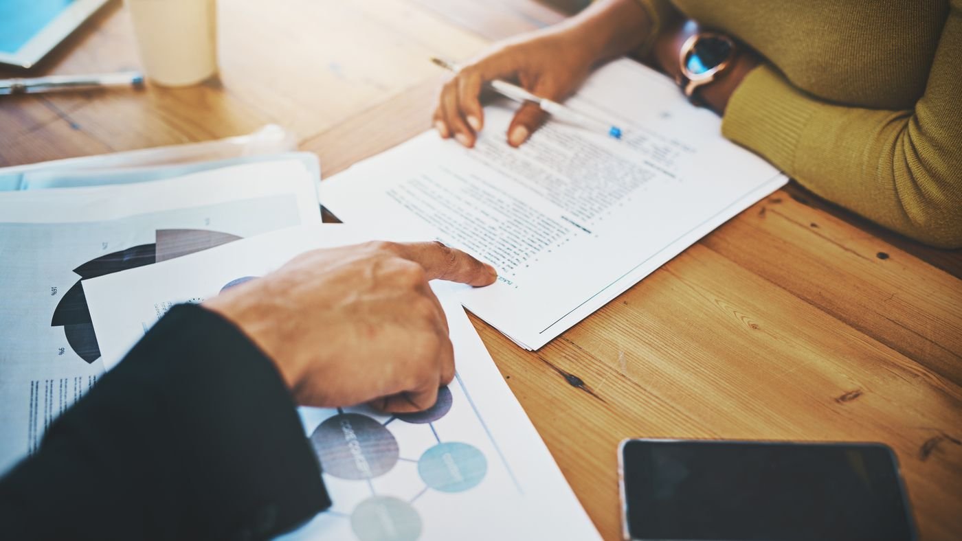 Analyse de documents chiffrés sur un bureau, stylo en main