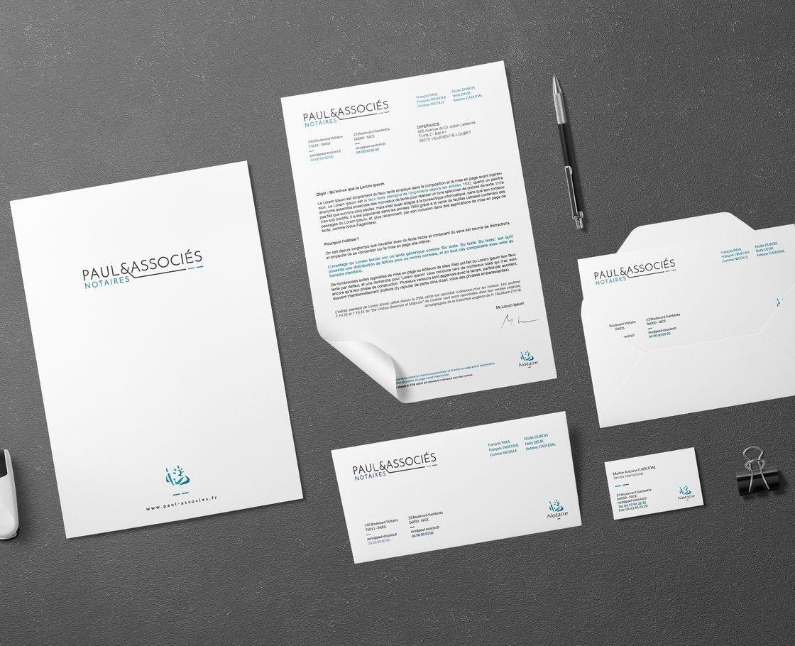 Papier en-tête, cartes et pochette disposés à plat sur un fond clair