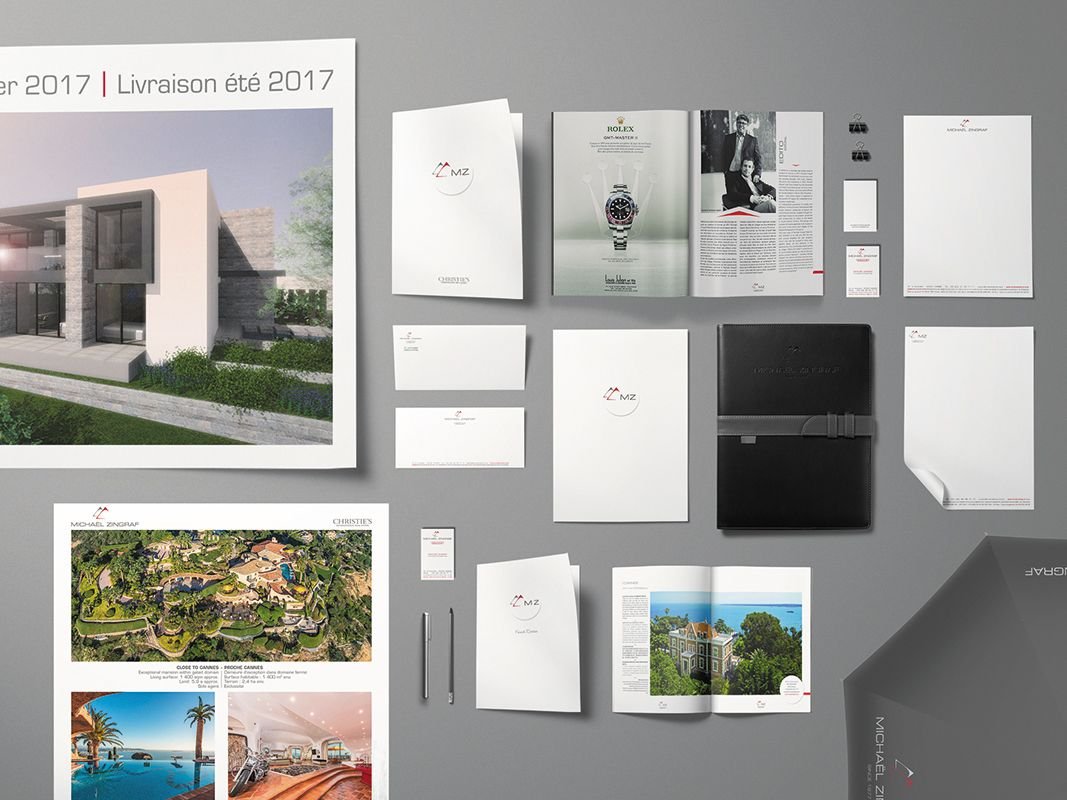 Gamme complète de supports de communication imprimés d'une agence immobilière, plaquettes, cartes et papeterie disposées à plat